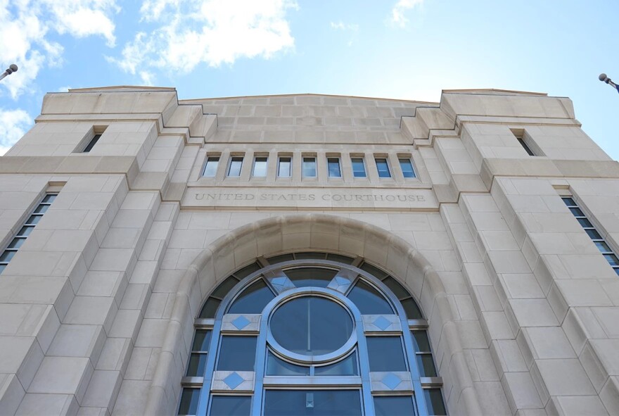 Facade of a beige stone building with signage that reads "United States Courthouse."