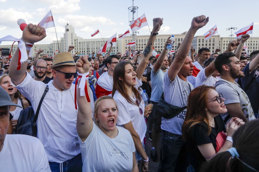 People with old Belarusian national flags shout during an opposition rally in August in Minsk, Belarus.