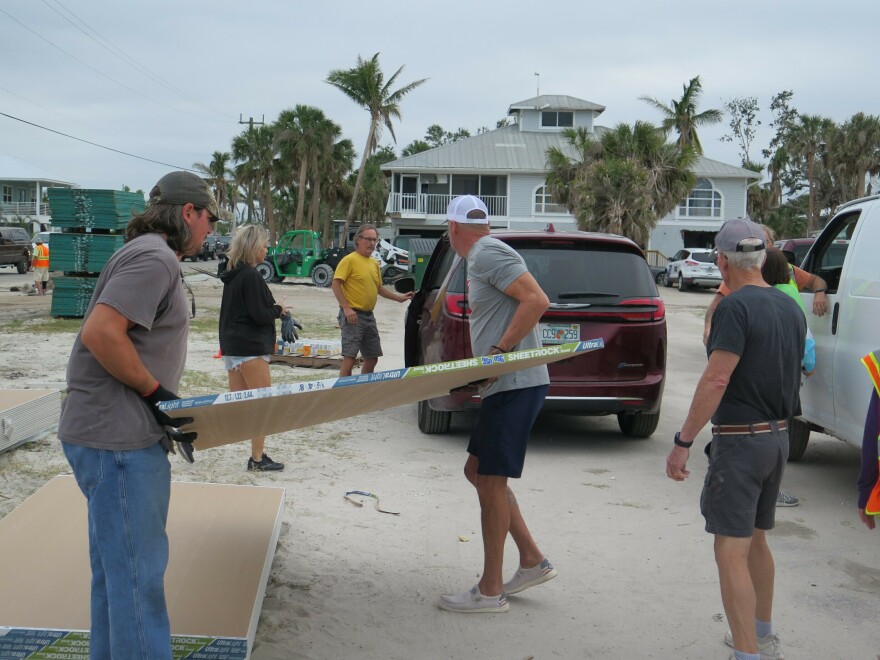Volunteers load free drywall into trucks and SUVs during a recent giveaway at Beach Baptist Church on Fort Myers Beach. Charlie Doster was among those collecting the maximum 25 sheets. "I need probably five times this many."