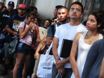 Young people wait in line to enter the office of The Coalition for Humane Immigrant Rights of Los Angeles (CHIRLA) on August 15, 2012 in Los Angeles, California, on the first day of the Deferred Action for Childhood Arrivals (DACA) program. US authorities began taking applications for deferred deportations from undocumented immigrants brought here as children, an initiative that could benefit up to 1.7 million people, as long lines of applicants, many who have long feared separation from their families and deportation from the country they've always considered home, formed outside consulates, advocacy offices and law firms. 