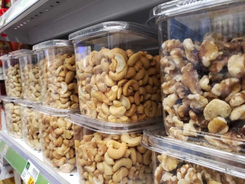 Nuts in plastic containers on a grocery shelf
