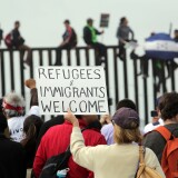SAN DIEGO, CA - APRIL 29: Pro-migrant caravan demonstrators rally at the west end of the U.S.-Mexico border as pro-migrant demonstrators climb the border wall from the Mexican side on April 29, 2018 in San Diego, California. More than 300 immigrants, the remnants of a caravan of Central Americans that journeyed across Mexico to ask for asylum in the United States, have reached the border to apply for legal entry. (Photo by Bill Wechter/Getty Images)