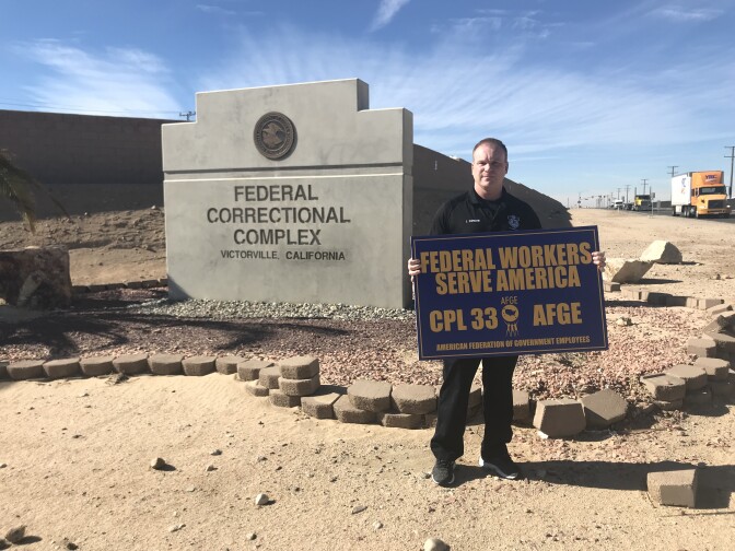 Corrections officer and union leader John Zumkehr stands in front of the entrance to the Victorville Federal Correctional Complex holding a picket sign. Workers here are going without a paycheck during the partial government shutdown. 