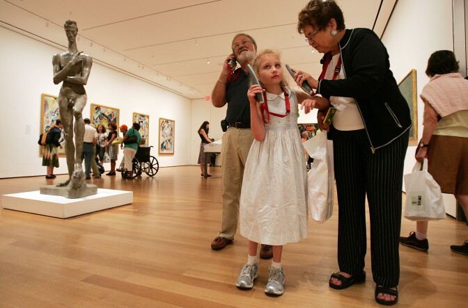 NEW YORK - JUNE 26:  Grandparents Richard and Barbara Grossman help granddaughter Talia, 7, listen to an audio tour during the annual Grandparent's Day at the Museum of Modern Art June 26, 2007 in New York City. Hundreds of grandparents and grandchildren enjoyed interactive gallery tours and hands-on art workshops.  (Photo by Mario Tama/Getty Images)