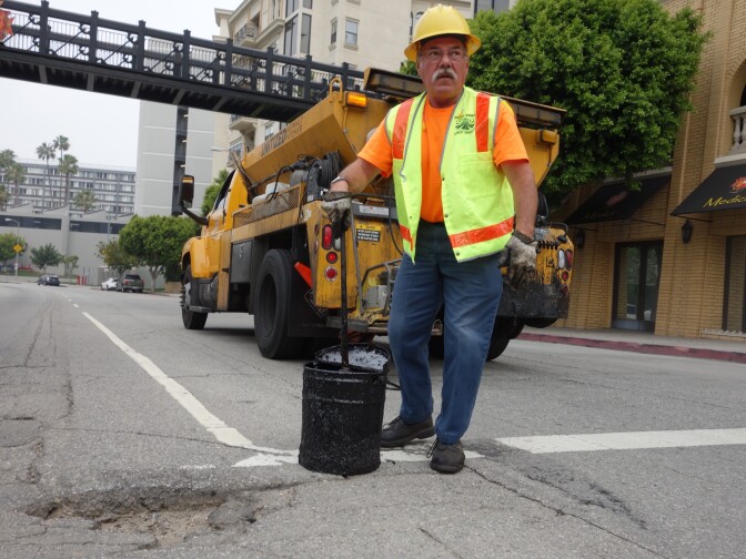 Los Angeles city worker Hugo Vasquez reviews a pothole that needs filling at 8th Street and Bixel Ave. downtown.