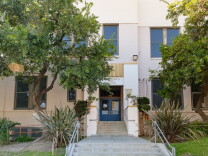 The exterior of a school with blue double doors.