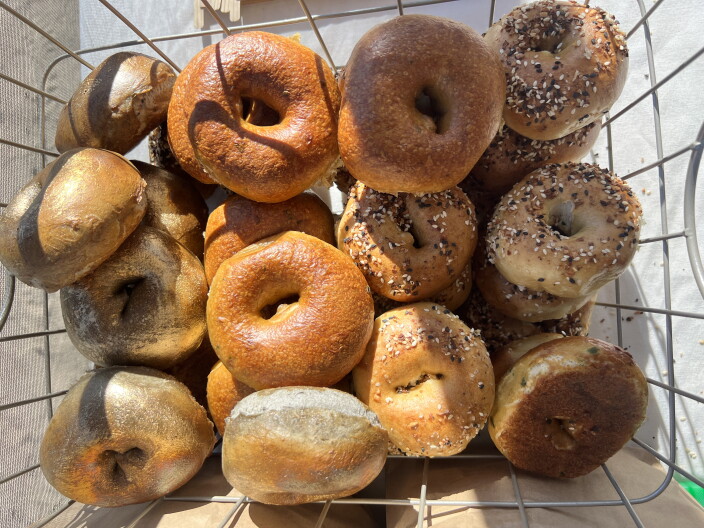 A bunch of bagels in a basket.