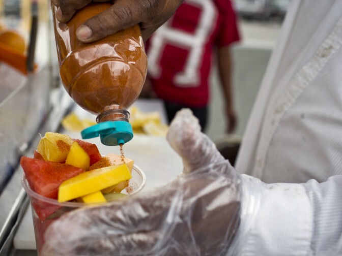 Delfina Flores puts chili powder and lime juice on fruit for a customer on Tuesday, Nov. 11, 2014 on Figueroa Street in Highland Park.