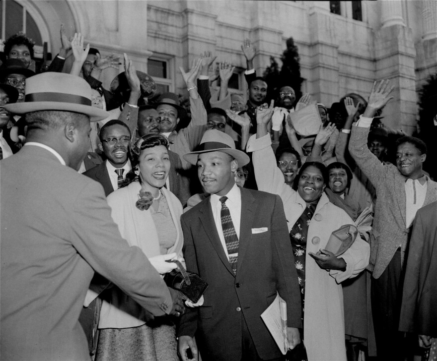 The Rev. Ralph Abernathy (left) shakes hands with the Rev. Martin Luther King Jr. in Montgomery, Ala., on March 22, 1956, as a big crowd of supporters cheers for King, who had just been found guilty of leading the Montgomery bus boycott.