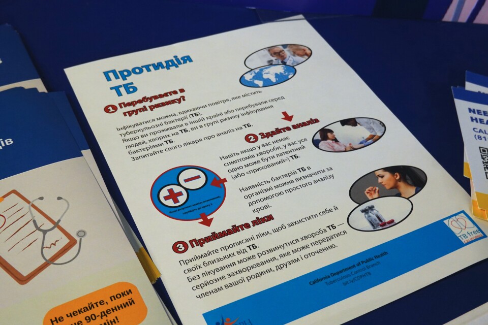 An informational public health flier in Ukrainian sits on a table.