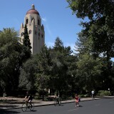 STANFORD, CA - MAY 22:  People ride bikes past Hoover Tower on the Stanford University campus on May 22, 2014 in Stanford, California. According to the Academic Ranking of World Universities by China's Shanghai Jiao Tong University, Stanford University ranked second behind Harvard University as the top universities in the world. UC Berkeley ranked third.  (Photo by Justin Sullivan/Getty Images)