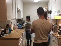 Lilia Tarverdi, left, cooks at home in Tujunga while her brother Argisht, right, holds one of her young children. Argisht, his older brother and their parents recently arrived as refugees from Iran after waiting nearly three years in Vienna.