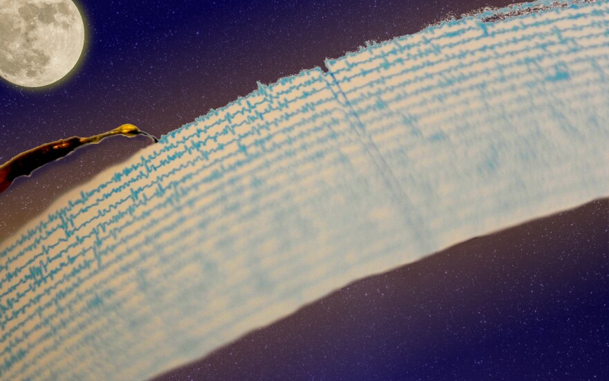 a stylus records motion on a seismograph, which is set against a dark blue nighttime sky that is full of stars. the moon is in the corner.
