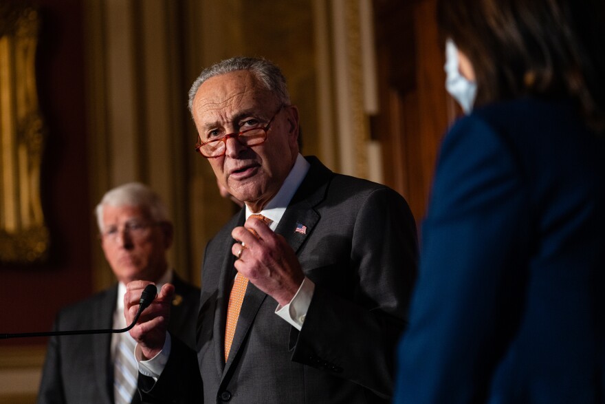An older white man in a suit is shown speaking.