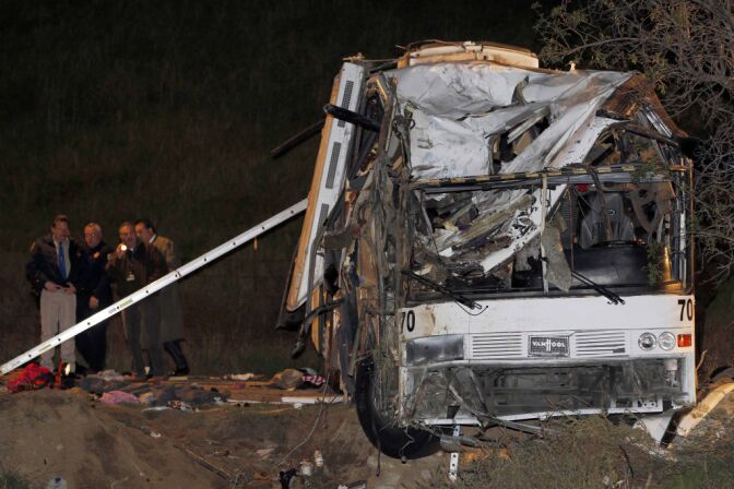 Investigators continue working the scene of a fatal tour bus crash near Yucaipa, Calif., Sunday, Feb. 3, 2013. (AP Photo/Nick Ut)