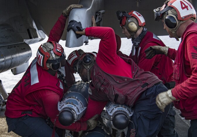 (Feb. 21, 2018) Sailors attach ordnance to an F/A-18C Hornet assigned to the “Blue Blasters” of Strike Fighter Squadron (VFA) 34 on the flight deck of Nimitz-class aircraft carrier USS Carl Vinson (CVN 70).