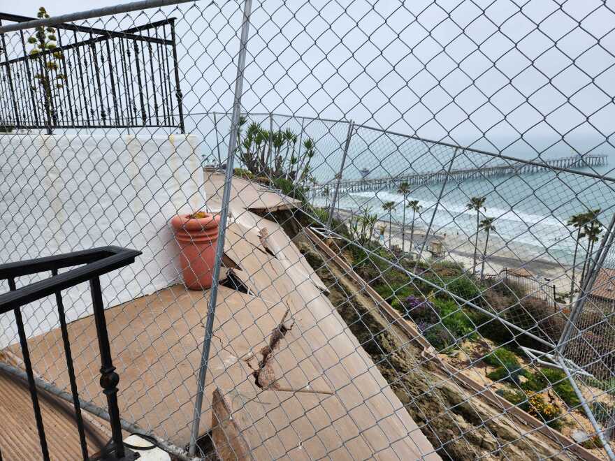 A tangled array of temporary fencing hangs in the void after the April 27 landslide snapped off the terrace and obliterated the garden at the rear of the historic home.