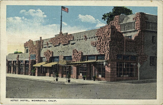 A postcard depicts the hotel, with its Mayan facade, on a street corner. An American flag flies from a pole on the roof.