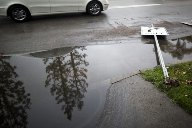 A street sign on Coldwater Avenue in Studio City is knocked over on Friday, Feb. 28 after an overnight rainstorm in Southern California.