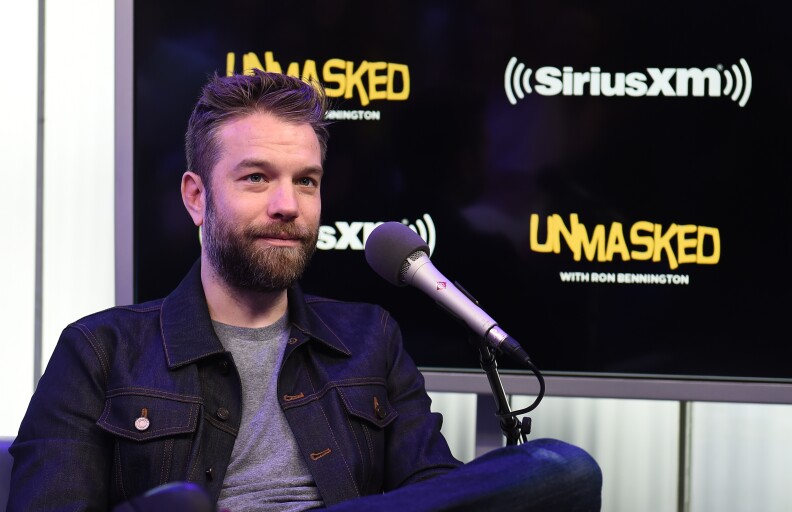 Comedian Anthony Jeselnik sits behind a microphone