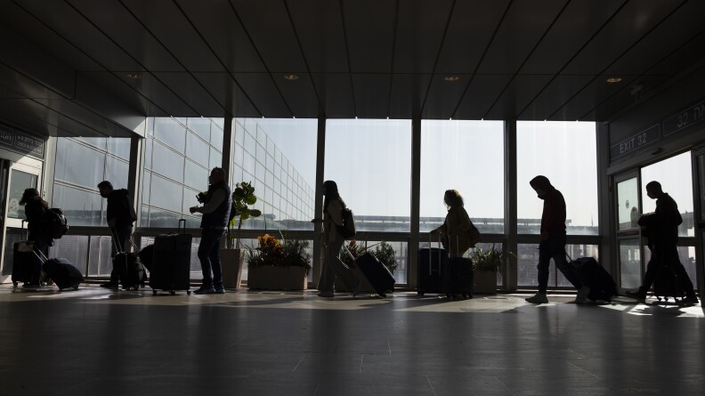 Travelers walk with their luggage in the Ben Gurion Airport near Tel Aviv, Israel on Sunday.