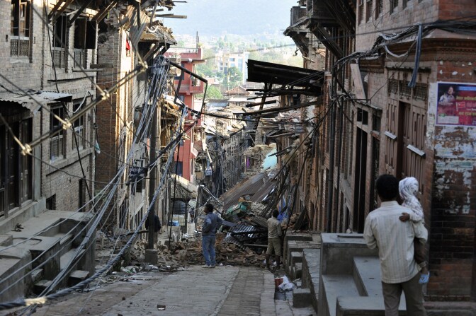 Residents look at collapsed houses in Bhaktapur, on the outskirts of Kathmandu, on April 27, 2015, two days after a 7.8 magnitude earthquake hit Nepal. Nepalis started fleeing their devastated capital on April 27 after an earthquake killed more than 3,800 people and toppled entire streets, as the United Nations prepared a "massive" aid operation.  AFP PHOTO / PRAKASH MATHEMA        (Photo credit should read PRAKASH MATHEMA/AFP/Getty Images)