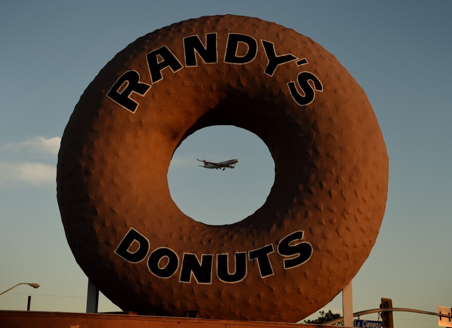A Swissair plane flies past Randy's Donuts which is an iconic landmark in the city of Inglewood, as it makes its descent into Los Angeles International Airport, California on January 24, 2016.  The recent announcement that the St. Louis Rams football team will relocate to a new stadium in Inglewood has started a property boom in the surrounding area.     AFP PHOTO / MARK RALSTON / AFP / MARK RALSTON        (Photo credit should read MARK RALSTON/AFP/Getty Images)