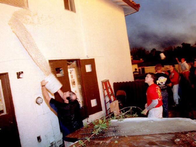 Residents throw water on their homes to prevent flames from gas main explosions from destroying their houses following a 6.6 earthquake Jan. 17, 1994.