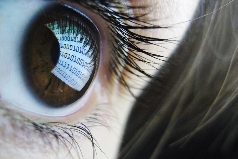 A pictures shows binary code reflected from a computer screen in a woman's eye on October 22, 2012. AFP PHOTO / LEON NEAL (Photo credit should read LEON NEAL/AFP/Getty Images)