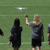 One person waves to the camera on a drone as people pose for a photo, July 3, 2016, at the Rose Bowl stadium in Pasadena, California.
NASA's solar-powered Juno spacecraft is scheduled to enter into orbit around Jupiter on July 4 to begin an in-depth study of the planet's formation, evolution and structure. The key event on July 4 is a 35-minute engine burn at 11:18 p.m. EDT (0318 GMT on Tuesday), which is designed to slow Juno down enough to be captured by Jupiter's powerful gravity. / AFP / Robyn Beck        (Photo credit should read ROBYN BECK/AFP/Getty Images)