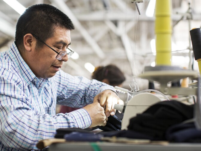 Byron Matthew sews cuffs onto sweatshirt sleeves at the manufacturing facility for Los Angeles Apparel, the new label started by American Apparel founder Dov Charney, in South Los Angeles on Thursday, June 8, 2017.