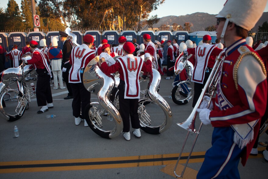 Members of the Wisconsin marching band take a pit stop before setting off on their six-mile trek down Colorado Boulevard on Monday morning.