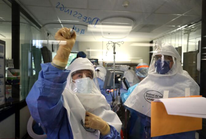 SAN JOSE, CALIFORNIA - MAY 21: (EDITORIAL USE ONLY) A nurse writes a note on a window as a team of doctors and nurses performs a procedure on a coronavirus COVID-19 patient in the intensive care unit (I.C.U.) at Regional Medical Center on May 21, 2020 in San Jose, California. Frontline workers are continuing to care for coronavirus COVID-19 patients throughout the San Francisco Bay Area. Santa Clara county, where this hospital is located, has had the most deaths of any Northern California county, and the earliest known COVID-19 related deaths in the United States. (Photo by Justin Sullivan/Getty Images)