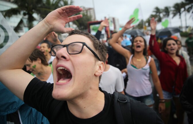 RIO DE JANEIRO, BRAZIL - SEPTEMBER 21:  Participants chant and sing during the climate march along Ipanema beach on September 21, 2014 in Rio de Janeiro, Brazil. Protests calling for curbs in greenhouse gas emissions were scheduled for today in 150 countries ahead a U.N. summit on climate change. The Amazon rainforest, mostly located in Brazil, produces about 20 percent of the earth's oxygen but is threatened by deforestation. (Photo by Mario Tama/Getty Images)