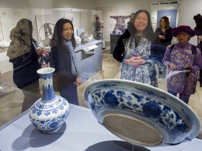 Christina Yu Yu, director of its USC Pacific Asia Museum, left, along with members of the media look at a cobalt-oxide porcelain charger and vase from the early Ming dynasty during a media tour of the newly renovated USC Pacific Asia Museum, December 6, 2017.  (Photo/Gus Ruelas)