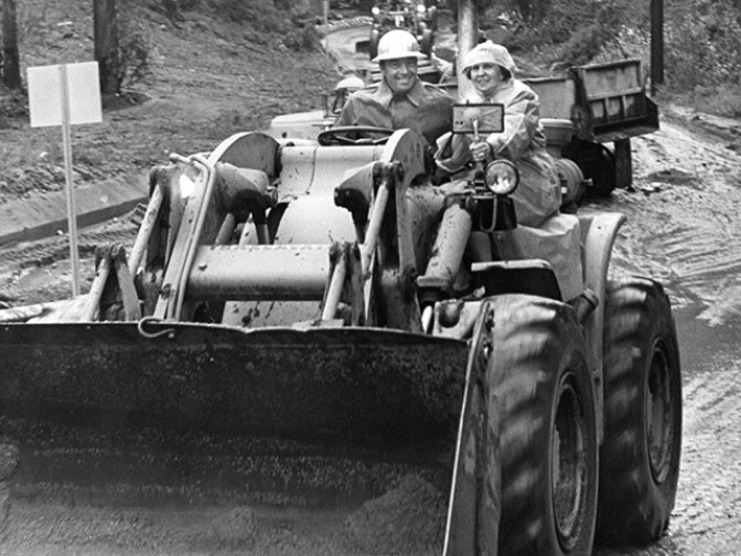 April 2, 1965: Burbank resident Mrs. Lucille Hanson rides on bulldozer to safety with operator A. K. Winkle. Earlier, she became stranded in her car along Country Club Drive in Burbank and had to be rescued by the city's assistant police chief, Robert Loranger. (Photo courtesy of the Los Angeles Public Library)