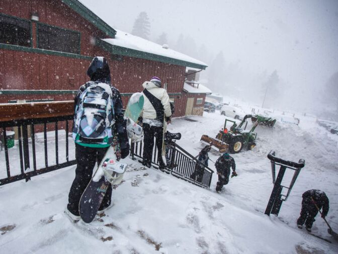 A tractor piled snow as more fell on one of the best days of the year for new powder at Bear Mountain. Business was down about 15 percent after police announced the lodge as the center of a manhunt for Christopher Dorner.