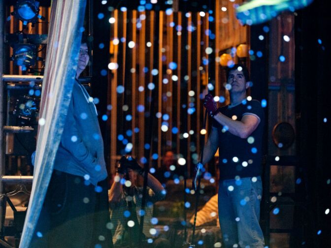 Flying choreographer Paul Rubin, right, pulls ropes that swing Rigby back and forth on a wire.