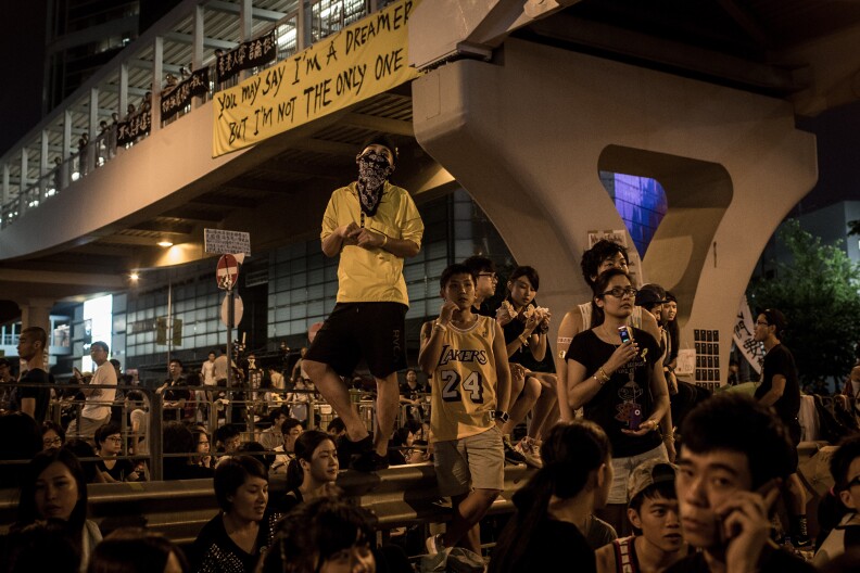 HONG KONG - OCTOBER 01:  Protesters listen to speeches outside the Hong Kong Government Complex on October 1, 2014 in Hong Kong, Hong Kong. Thousands of pro democracy supporters continue to occupy the streets surrounding Hong Kong's Financial district. Protest leaders have set an October 1st deadline for their demands to be met and are calling  for open elections and the resignation of Hong Kong's Chief Executive Leung Chun-ying.  (Photo by Chris McGrath/Getty Images)