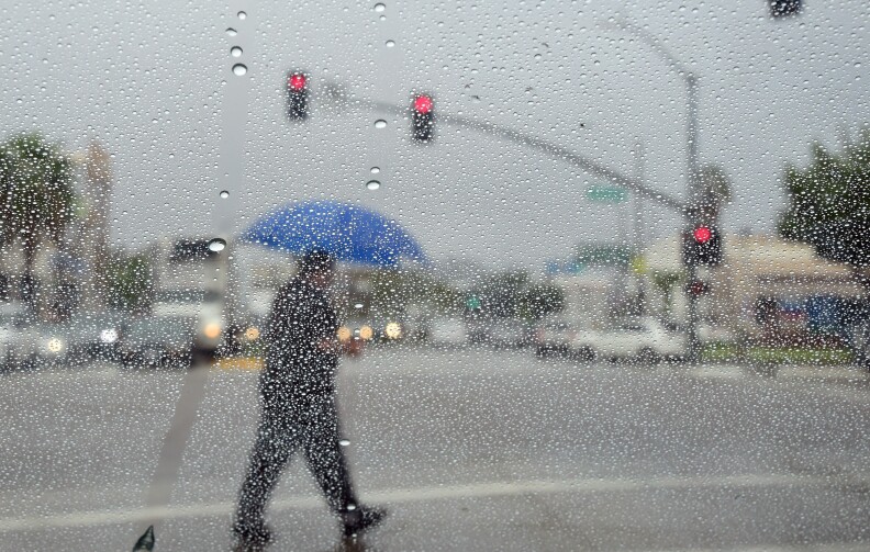 File: A man crosses a street during a steady rainfall on Sept. 15, 2015 in L.A., as a low-pressure system filled with moisture from a former tropical cyclone unleashed heavy rain.