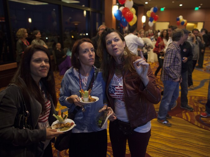 Shannon Mahoney, left, Katie Brennan and Patricia Sill watch polling numbers come in during Marianne Williamson's election party at the Marriott in Marina del Rey.