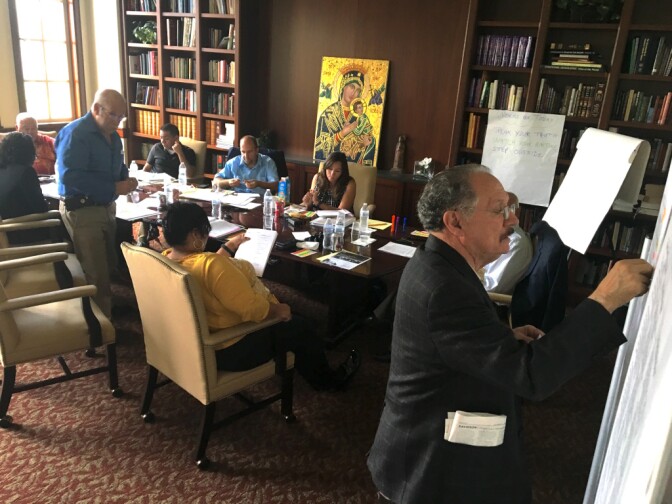 Los Angeles Unified School Board vice president George McKenna places a sticker on a poster during a goal-setting exercise at a meeting of the board's Committee of the Whole at the USC Caruso Center on Sept. 27, 2016.