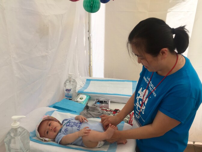 March for Science L.A. volunteer Amy Kim changes her four-month-old daughter Chloe in the march’s family tent on April 14, 2018.