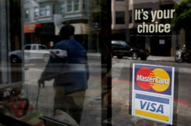 A window sticker advertising Visa and MasterCard credit cards hangs in a window in San Francisco, California.