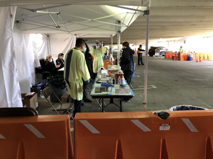 Nurses prepare doses of vaccine to protect against Covid-19 at a drive-through vaccination clinic in a parking structure at Cal State Long Beach.