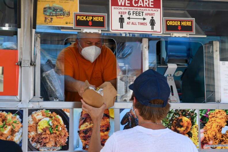 Tom Tulus, co-owner of StopBye Cafe, hands out an order