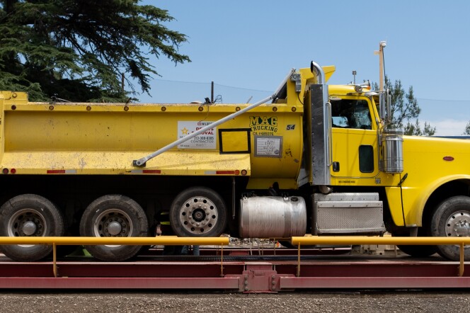 A yellow dump truck on a red platform.