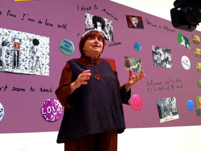 Agnes Varda in front of a collage of some of her photos and sayings, at the new installation at BCAM, "Agnes Varda in Californialand."
