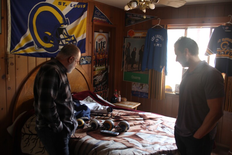 Ernie Garcia showing A Martinez some of his collectibles 