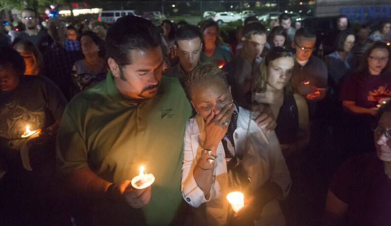 Roanoke City Council member Anita Price, right, is comforted by friend Jan DeVries as they show their community support at a candlelight vigil in front of the studios of WDBJ-TV in Roanoke, Va., Thursday, Aug. 27, 2015, a day after reporter Alison Parker and cameraman Adam Ward from the station were killed during a live broadcast. (AP Photo/Don Petersen)